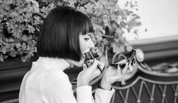 Chica morena con lápiz labial mirando en el espejo comprobar su apariencia de maquillaje. Concepto de secretos femeninos. Mujer haciendo maquillaje con espejo de bolsillo. Comprueba si todo está justo antes de la fecha. Concepto de maquillaje — Foto de Stock