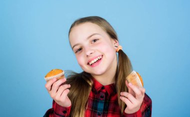 O kadar tatlı ki yemeğin tadını güzel yapıyor. Küçük kız taze pişmiş tatlı gıda ile gülümseyen. Mutlu küçük çocuk ev bardak pişmiş yiyecek tutarak. Bu tatlı yiyeceklerden kaç tane yemeyi seviyorsun?