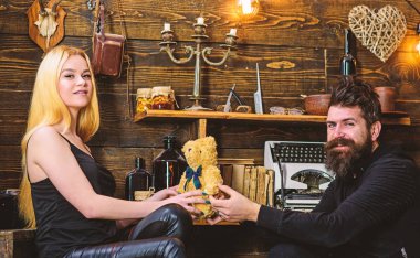 Adam Bayan oyuncak ayı için yıldönümü hediye olarak vermek. Gülümseyen yüzler üzerinde aşık çift tatilin keyfini çıkarın. Yıldönümü kavramı. Çift Romantik akşam gamekeepers evinde, ahşap iç arka plan geçirmek.