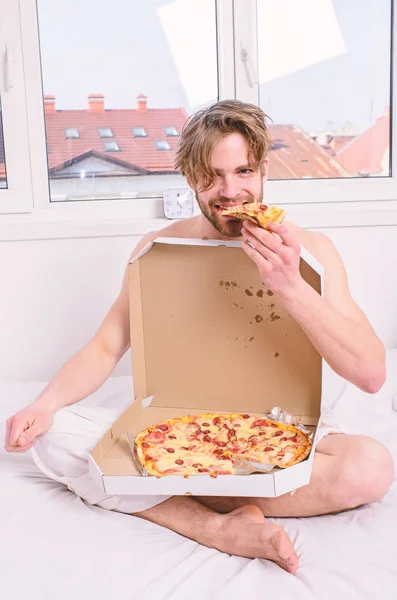 Man bearded handsome eat pizza. Man eat pizza breakfast. Guy naked covered pizza box sit bed bedroom offer you join him. Sexy courier delivers gastronomic satisfaction. Gastronomic satisfaction