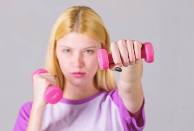 Kız tutun dambıl. Pazı egzersizleri kadın için. Fitness eğitmeni. Sağlıklı yaşam konsepti. Kadın spor hocası dumbbells ile egzersiz. Kolay egzersizler dumbbells ile. Egzersiz dumbbells ile
