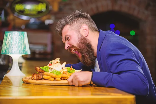 Cheat meal concept. Hipster hungry eat pub fried food. Manager formal suit sit at bar counter. Delicious meal. Man received meal with fried potato fish sticks meat. High calorie snack. Enjoy meal