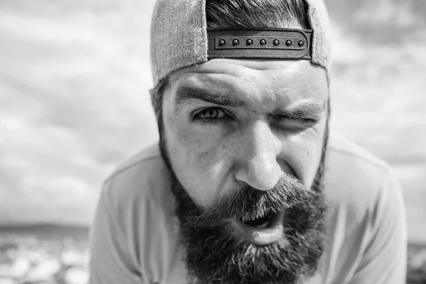 Hipster com sardas viradas de perto. Homem com barba no dia de sol. Cuidados com a pele e bronzeado. Hipster barbudo com bigode elegante. Jovens e despreocupados. Tampa de desgaste hipster barbudo. Conceito de primavera — Fotografia de Stock