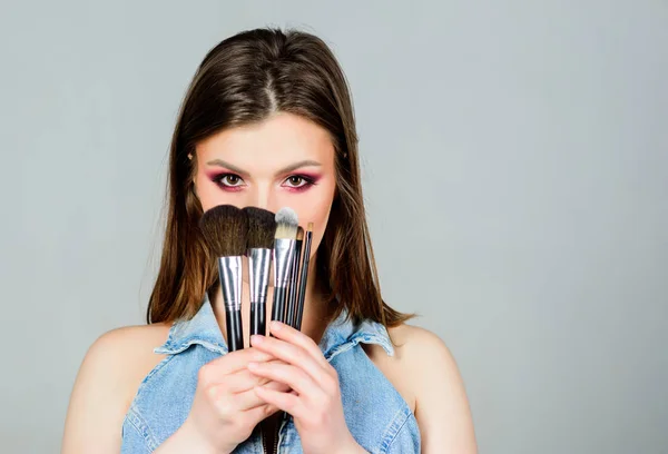 Cepillos diferentes. Cuidado de la piel. Maquillaje concepto de cosméticos. Ocultador de tono de piel. Tienda de cosméticos. Chica aplicar sombras de ojos. Mujer aplicando cepillo de maquillaje. Enfatiza la feminidad. Maquillaje profesional suministros —  Fotos de Stock