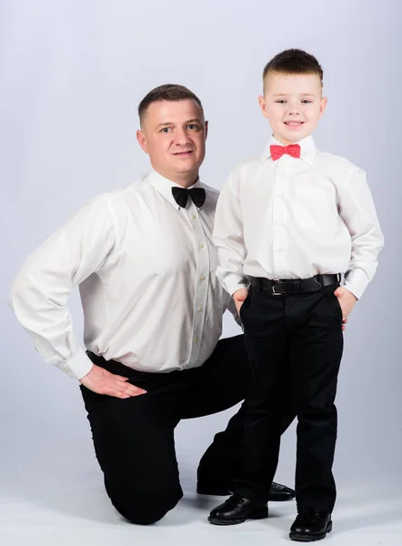 Gentleman upbringing. Formal event. Little son following fathers example of noble man. Gentleman upbringing. Father and son formal clothes outfit. Grow up gentleman. Dad and boy with bow ties