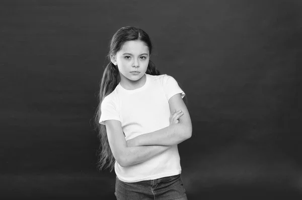 Elegante y seguro. Lindo niño pequeño. Chica de moda sobre fondo rojo. Niña adorable en estilo casual. Niño pequeño con el pelo largo con estilo. Pequeña fashionista. Aspecto de moda de modelo pequeño — Foto de Stock