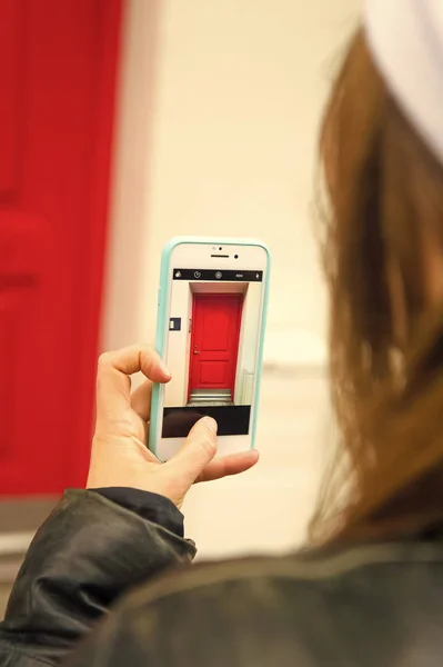 Someone taking mobile photo house entrance with red door. Daily photo shooting. Mobile app camera. Tourist photographer concept. App for shooting mobile phone photos high quality