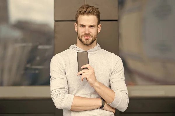 Modern life concept. Handsome man use mobile phone in modern life. Young guy hold mobile device, modern life. Smartphone is an integral part of modern life