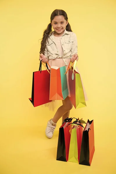 Pacote e menina. menina com pacote colorido. pacote de compras na mão da menina. Menina com saco de pacote. pequeno shopaholic. — Fotografia de Stock