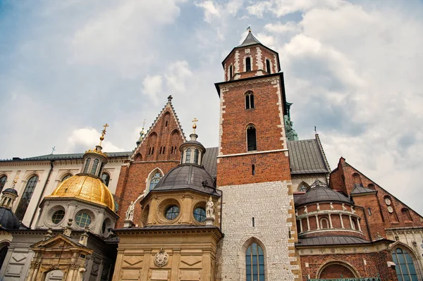 Old city architecture concept. Tower belfry with steeples in Krakow. Architectural heritage. Old or ancient church or cathedral with many window made out of red brick. Tower with cross on top of roof — Stock Photo, Image