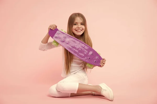 Happy little girl with penny board. Little girl happy smiling with penny board. Regenerate energy skating from day to night. Vital energy. A skateboard you can trust