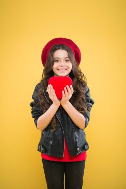 Romantik bir ruh hali. Kalbimle oynama. Sevgililer gününü kutla. Aşk konsepti. Kız sevimli çocuk göstermek kalp oyuncak. Aşkın kalp sembolü. Çocuk şık modern kız mutlu yüz göstermek kalp sarı arka plan