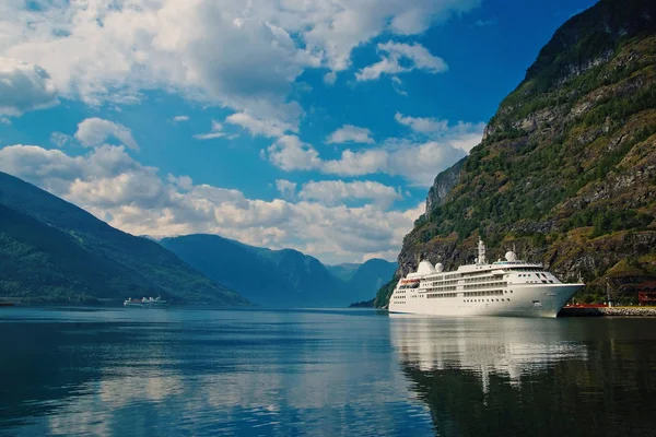 Διακοπές πλοίο στο λιμάνι της θάλασσας στο ορεινό τοπίο στο Flam, Νορβηγία. Υπερωκεάνιο στο λιμάνι της θάλασσας με το πράσινο των βουνών. Προορισμός κρουαζιέρας και ταξίδια. Καλοκαιρινές διακοπές και διακοπές. Wanderlust και ανακάλυψη — Φωτογραφία Αρχείου