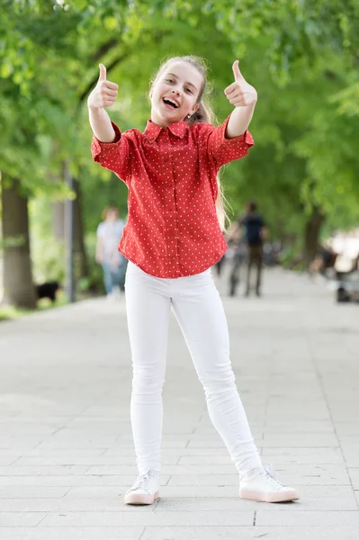 Kul och spela hela dagen. Söt liten flicka gest tummen UPS spelar utomhus. Bedårande litet barn som njuter av lekaktiviteter på sommaren. Lekterapi för barn. Lek tid som en del av barndomens utveckling — Stockfoto