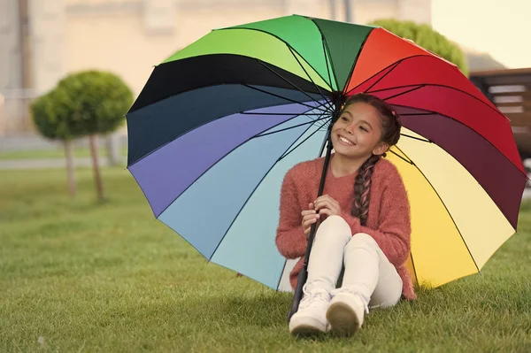 우산 아래에 앉아 하 고 재미입니다. 비를 기다리는 공원에 작은 소녀. 행복의 개념으로 다채로운 우산입니다. 무지개만 수 있습니다. 웃 고 행복 한 작은 여자 — 스톡 사진