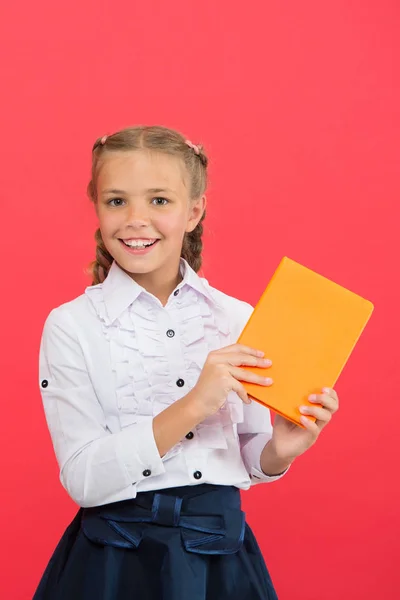All hennes kunskap är från bok. Bedårande liten flicka som håller bok på röd bakgrund. Sött litet barn med bok kunskap i händerna. Kunskaper. Kunskaps dag eller 1 september, kopiera utrymme — Stockfoto