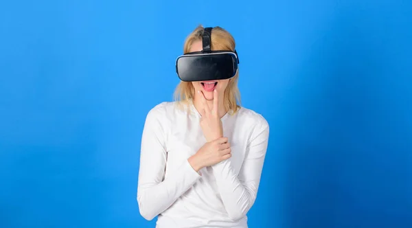 Szép nő játszik a virtuális valóság szemüveg. Nő visel virtuális valóság szemüveg kék háttér. Izgatott mosolygó üzletasszony visel virtuális valóság szemüveg. — Stock Fotó
