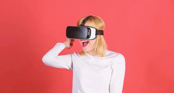 Retrato de mulher em uma blusa branca com óculos de realidade virtual na cabeça isolada em fundo vermelho. Jovem confiante ajustando seu fone de ouvido de realidade virtual e sorrindo . — Fotografia de Stock