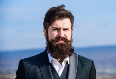 Adam sakallı hipster resmi takım mavi gökyüzü arka plan giymek. Vintage tarzı uzun sakal. Sakal ve bıyık bakımı. Sakal moda trendi. Şık bir görünüme yatırım yapın. Kalın sakalı hızlı uzatın