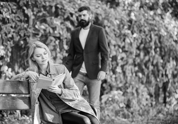 Mann kam zu Freundin auf Date. Überraschung für sie. Mädchen sitzen Bank lesen Buch, während warten Freund. romantische Beziehungen. romantisches Date. Paar verliebt romantisches Datum Naturpark Hintergrund — Stockfoto