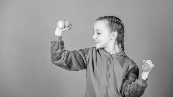 Entrenamiento de niña pequeña sostener mancuerna. Dieta fitness para la salud energética. levantamiento de pesas para el músculo. Actividad infantil. Éxito deportivo. Niño deportista feliz con barra. club de fitness. deporte y fitness — Foto de Stock