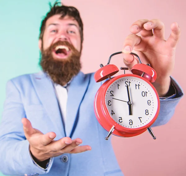 Man bearded happy cheerful businessman hold alarm clock. Timely concept. Hipster happy working day is over. Businessman finished on time. Time management skills. Best time of day. Just in time