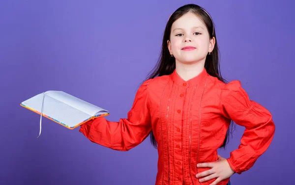 The library is the temple of learning. Confident small child holding library book. Adorable little library reader with open book. Reading in a school library, copy space — Stock Photo, Image