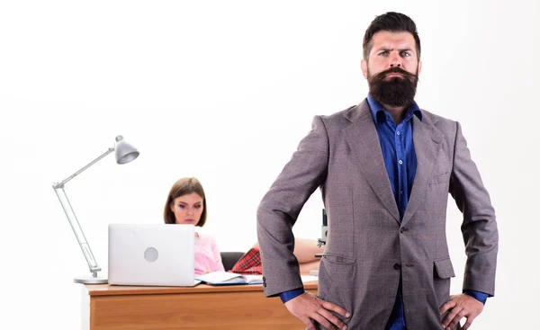 Feeling confident. Confident businessman and female coworker in office. Confident caucasian man with pretty woman working in background. Confident boss with long beard in formal wear