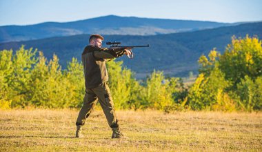 Avcı tüfeği hayvan için arıyorum. Avcılık atıcılık kupa. Adam tüfek av için. Bireysel işlem avcılık zihinsel hazırlığı. Silah Dağları arka plan avcı haki elbise avlamak hazır tutun