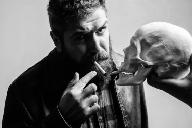 Sigara zararlı olduğunu. Tütün sigara içmeyi alışkanlık vücudunuza zarar getir. Adam ölüm sembolü insan kafatası yakınındaki Sigara İçilmeyen. Zararlı alışkanlıklar. Sigara sağlık zarar ve ölüm. Sağlık yok