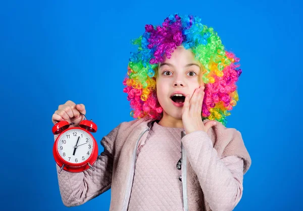 Kid kleurrijke krullend pruik clown stijl Hold alarm clock. Ik ben geen grapje over discipline. Vals alarm. Meisje zorgen over de tijd. Tijd om plezier te hebben. Discipline en tijd concept. Circus performance timing — Stockfoto