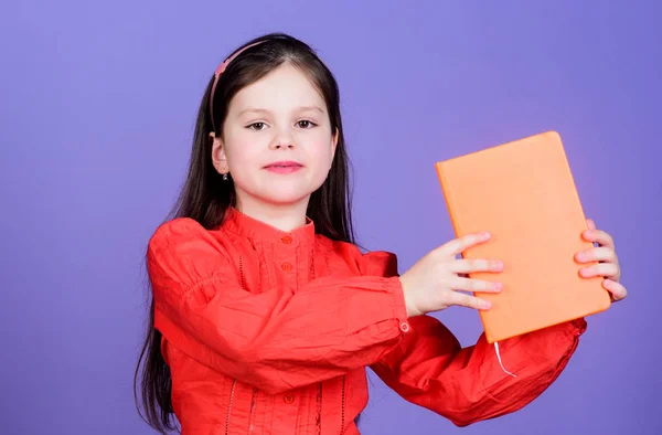 Αφιερωμένο στην εκπαίδευση. Ένα κοριτσάκι που κρατά το εκπαιδευτικό βιβλίο με πορτοκαλί κάλυμμα. Χαριτωμένο μικρό παιδί να πάρει επίσημη εκπαίδευση στο δημοτικό σχολείο. Πλήρως απολαμβάνοντας το δικαίωμα στην εκπαίδευση, αντιγράψτε το χώρο — Φωτογραφία Αρχείου