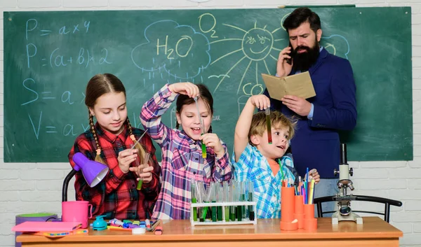 En busca de una solución médica adecuada. de vuelta a la escuela. niños con bata de laboratorio aprendiendo química en el laboratorio escolar. laboratorio de química. haciendo experimentos en laboratorio o gabinete químico. feliz maestro de niños — Foto de Stock