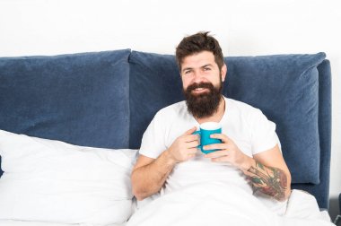Sakallı adam sabah kahvesi içiyor. Yeni güne uyum içinde. Sabah fincan kahve ile daha iyi uyanma. Rahatla ve dinlen. İnsanlık kahveyle çalışır. Adam acımasız yakışıklı hipster rahatlatıcı yatak odası içki kahve