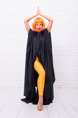 Poz ver. Yalınayak bir dansçı. Şehvetli dansçı mı yoksa beyaz duvarda dans eden kız mı? Sarı peruklu ve siyah mantolu güzel bir dansçı. Çağdaş balede seksi dansçı pozisyonu