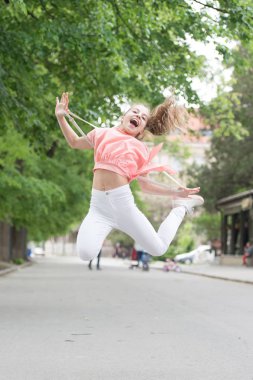 Daha aktif ve dinamik oluyor. Mutlu küçük çocuk zevk için aktif atlama. Aktif küçük çocuk kentsel arka planda hareket ediyor. Aktif ve enerjik kız yaz aylarında eğleniyor