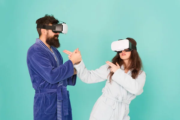 Il futuro e 'piu' vicino di quanto pensi. Tecnologia VR e futuro. Comunicazione VR. Impressioni emozionanti. Coppia in accappatoi indossano occhiali VR. Gioco e intrattenimento. Uomo e donna esplorano la realtà virtuale a casa — Foto Stock