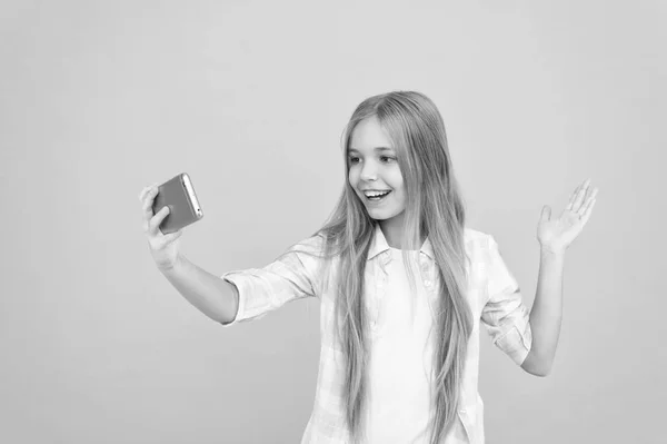 Hej världen detta är min kanal. Låt mig ta selfie. Barn tjej håll smartphone. Videosamtal-konceptet. Flickan håller smartphone tar selfie. Selfie för sociala nätverk. Streaming online eller skytte vlog — Stockfoto