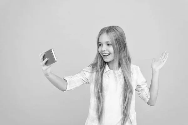 Ciao mondo questo è il mio canale. Fammi fare un selfie. Bambino ragazza tenere smartphone. Concetto di videochiamata. Ragazza tenere smartphone scattare selfie. Selfie per i social network. Streaming online o riprese vlog — Foto Stock