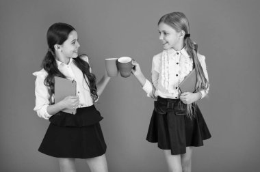 Çay molası sırasında içme. Okul arkadaşları ile içki rahatlatıcı. Öğrenci olmanın tadını çıkarın. Kız çocuklar okul üniforması turuncu arka plan. Kız öğrenci kitap veya Not defteri ve kupa tutun. Okul rutin. Sakin ol molası