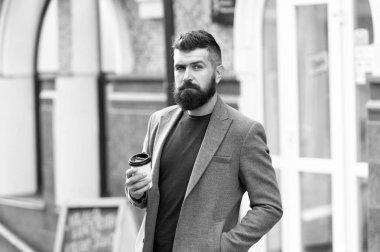 İş adamı iyi bakımlı bir görünüm kahve molası dışında iş merkezi tadını çıkarın. Dinlenmek ve şarj. Adam kahve kağıt bardak içme hipster sakallı. Daha fazla bir yudum kahve. Üstünde belgili tanımlık gitmek kahve keyfi