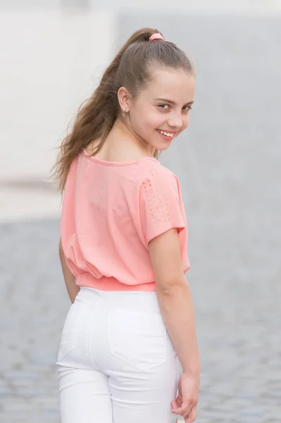 Sonriente belleza. Feliz chica de belleza en el día de verano. Belleza mirada de niña adorable en el fondo urbano. Niño pequeño con sonrisa encantadora en la cara de la belleza y el pelo largo hermoso —  Fotos de Stock