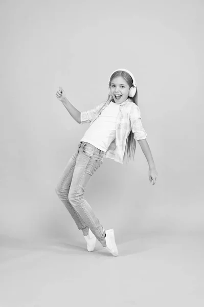 Cette chanson a de l'énergie. Petite fille écoutant de la musique dans les écouteurs. Une danseuse. Joyeux petite fille dansant sur la musique. Enfant mignon appréciant la musique de danse heureuse. La musique est le bonheur pour elle — Photo