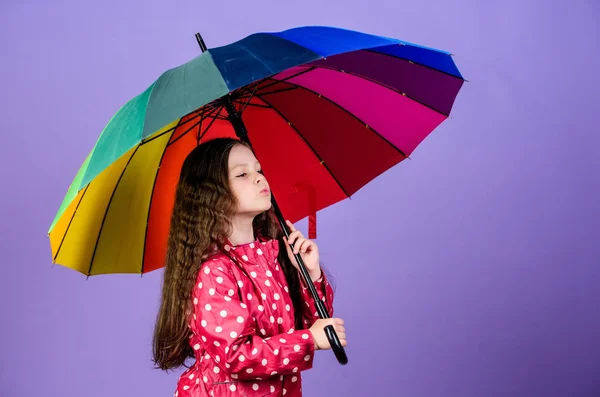 Tempo piovoso con indumenti adeguati. Un ombrello luminoso. Sii arcobaleno in qualche nuvola. Giornata di divertimento piovoso. Felice passeggiata sotto l'ombrello. Godetevi il concetto di pioggia. Ragazza felice tenere colorato ombrello arcobaleno — Foto Stock