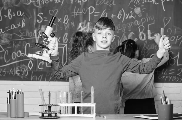 生体分子を探索します。将来の技術と科学のコンセプトです。少年は、学校の教室で顕微鏡と試験管を保持します。生物学および化学の学校での子供を学習します。学校教育。独自研究 — ストック写真