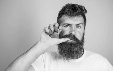 Taze meyve suyu kavramı. Adam içki saman mavi arka plan olarak çilek suyu emmek başparmak içer. Sakallı hippi çilek yumruk suyu şişe tutar. Adam kesin yüz zevk taze içki çilek suyu