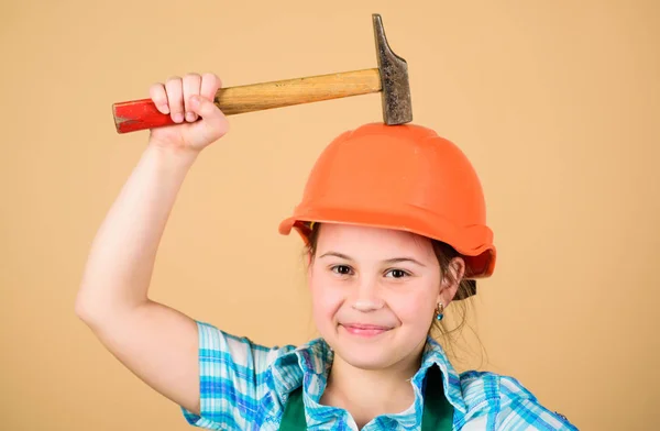 Día del Trabajo. 1 de mayo. Experto en seguridad. Profesión futura. Inspector Foreman. Reparar. Niña con casco y martillo. Trabajadora de niños con gorra dura. niña pequeña reparación en el taller. Mecánico de confianza — Foto de Stock