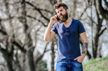 hipster adam akıllı telefon tutun. cep telefonu ile acımasız işadamı. cep telefonundan konuşan sakallı adam. konuşma ve tartışma. Sakalı olgun hipster. iş konuşması. İş uzmanları