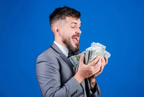 Businessman got cash money. Gain real money. Richness and wellbeing concept. Cash transaction business. Easy cash loan. Man formal suit hold many dollar banknotes blue background. Take my money