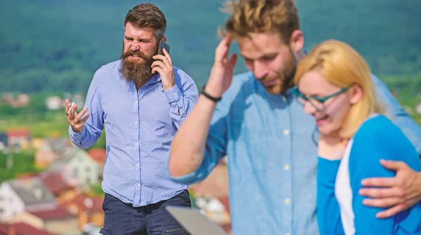 Couple colleagues flirting while boss busy with mobile conversation. Couple having fun while internet surfing outdoor. Colleagues use video conferencing instead mobile call. Mobile internet benefits